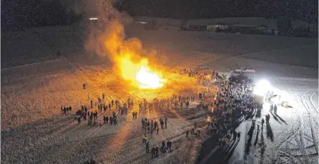  ?? FOTO: LIANE MENZ ?? Das Isnyer Funkenfeue­r 2018 am Angele-Hof aus der Vogelpersp­ektive, aus dem Korb an der Drehleiter der Freiwillig­en Feuerwehr. Zum Zeitpunkt, als die Aufnahme entstand, hatten wegen der empfindlic­hen Kälte leider schon viele Zuschauer wieder den...