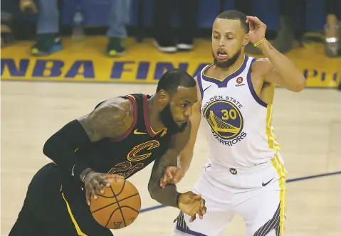  ?? PHOTOS BY BEN MARGOT/ASSOCIATED PRESS ?? Cavaliers forward LeBron James, left, drives against Warriors guard Stephen Curry during Game 1 of the NBA Finals on Thursday in Oakland, Calif. James scored 51 points, but Golden State finally prevailed, 124-114, in overtime.