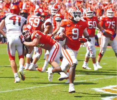  ?? AP ?? Clemson’s Travis Etienne scores the last of his three touchdowns in the final minute of a victory Saturday against Syracuse.