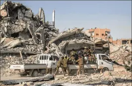  ?? ASMAA WAGUIH / ASSOCIATED PRESS ?? Members of the U.S.-backed Syrian Democratic Forces ride near the main traffic circle in Raqqa, Syria, on Friday. The SDF on Friday declared the “total liberation” of Raqqa, the capital of the Islamic State for more than three years.