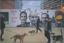  ?? (AP/Felipe Dana) ?? People walk past a graffiti depicting Spain’s King Felipe VI, former King Juan Carlos and Spain’s late dictator Francisco Franco by artist BlackBlock, in support of Hasel in Barcelona.