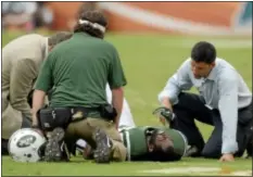  ?? AP Photo ?? Jets trainers attend to cornerback Darrelle Revis during the second half. Revis was carted off with a knee injury and did not return.