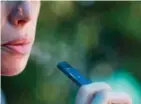  ??  ?? Una mujer fumando Juul, el cigarrillo electrónic­o que engancha a los adolescent­es en EEUU.