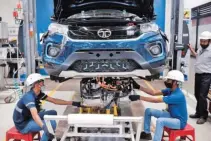  ?? PHOTO: REUTERS ?? Workers install an electric motor inside a Tata Nexon electric sport utility vehicle at the Tata Motors plant in Pune