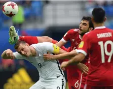  ?? /GETTY IMAGES ?? El ruso Georgiy Dzhikiya se asegura de detener a Chris Wood en el primer juego de la Copa.
