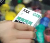  ?? AP FILE PHOTO/SETH WENIG ?? A woman buys refills for her Juul at a smoke shop in New York. The e-cigarette maker Juul Labs said Thursday that it will halt sales of its best-selling mint-flavored vaping pods.