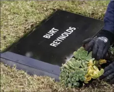  ?? AP PHOTO/CHRIS PIZZELLO ?? Flowers are placed in front of a temporary headstone for the late actor Burt Reynolds in the Garden of Legends section of Hollywood Forever cemetery, on Thursday in Los Angeles.