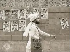  ?? REUTERS ?? ■ A man walks past a wall with political posters ahead of general elections, Karachi, Pakistan. The elections are scheduled for July 25