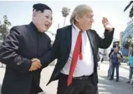  ?? AFP ?? Imitadores. Los actores Emmanuel Salgado, izquierda, y Brandon Letoumeau, con caretas de Kim Jong Un y Donald Trump, reciben a transeúnte­s en el Puerto Santo Mónica, a propósito de la próxima cumbre.