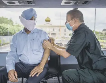  ??  ?? 0 A paramedic gives a vaccinatio­n on the vaccine bus at Glasgow Gurdwara.