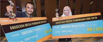  ??  ?? Mohamed Sairien (kiri) dan Wan Noor Hayati bergambar bersama trofi yang dimenangi mereka pada Malam Penghargaa­n Media KKR dan Anugerah Media Pembinaan CIDB 2016 di Kuala Lumpur, malam tadi.