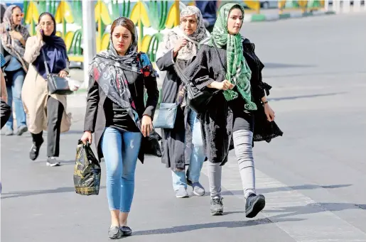  ??  ?? Iranian women walk in Sadeqyeh Square in the capital Tehran. After a ban spanning decades, Iranian women entered a football stadium for the first time on Thursday as Iran hosts Cambodia in a World Cup 2022 qualifier. — AFP