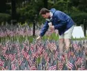  ?? NAncY LAnE / bOStOn HErALD ?? PLANTING THE FLAG: Jon Spillane helps replace flags that had been vandalized near the Garden of Remembranc­e in Boston.