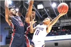  ?? John Minchillo/Associated Press ?? ■ Prairie View A&amp;M's Dennis Jones (11) shoots against Fairleigh Dickinson's Mike Holloway Jr., center, and Kaleb Bishop (12) during the second half of a First Four game of the NCAA basketball tournament Tuesday in Dayton, Ohio.