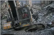  ?? BERNAT ARMANGUE — THE ASSOCIATED PRESS ?? An excavator driver waits for a rescue team to recover the body of an earthquake victim from a collapsed building in Antakya, Turkey, on Sunday.