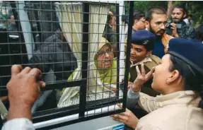  ??  ?? A protester (centre) is detained by police in Ahmedabad yesterday.