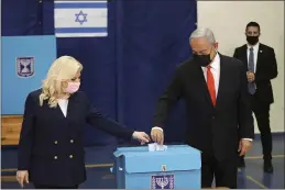 ?? RONEN ZVULUN — POOL ?? Israeli Prime Minister Benjamin Netanyahu and his wife, Sara, cast their ballots at a polling station in Jerusalem on Tuesday.