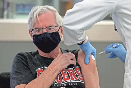  ?? ANGELA PETERSON/MILWAUKEE JOURNAL SENTINEL ?? TOP: Robert Kempka, 73, receives a COVID-19 vaccine at Infinity Pharmacy in Milwaukee.