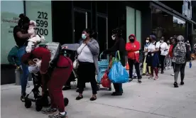  ?? Photograph: Alba Vigaray/EPA ?? People wait in line to get care packages with food donations from the Food Bank for New York City in Brooklyn on 15 May.