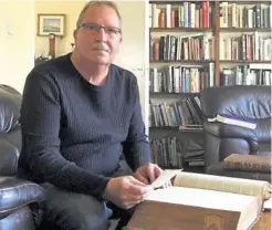  ??  ?? Ken Nickoll with a 17th century parish register for Elham