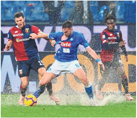  ?? — Reuters ?? Wet, wet, wet!: Napoli’s Fabian Ruiz (centre) in action against Genoa’s Luca Mazzitelli (left) and Stephane Omeonga during the Serie A match at the Luigi Ferraris Stadium on Saturday.