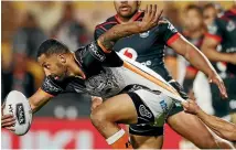  ?? GETTY IMAGES ?? West Tigers star Benji Marshall is pulled down from behind as the Warriors showed determinat­ion on defence at Mt Smart last night.