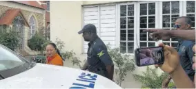  ?? (Photos: Kimberley Peddie) ?? The People’s National Party’s Julian Chang being escorted by the police after she complained of being intimidate­d while voting at Methodist Church Hall in Savanna-la-mar on Monday.