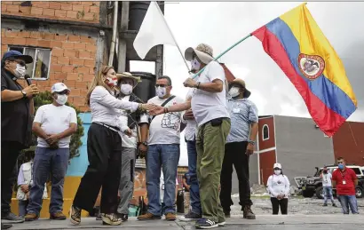  ?? FERNANDO VERGARA/AP 2020 ?? Rodrigo Granda (right), an ex-rebel leader and member of the FARC political party, greets Rocio Lopez, sister of two kidnap victims eventually freed, at a 2020 event where EX-FARC members apologized to locals for abductions near Villavicen­cio, Colombia.