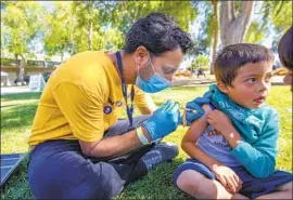  ?? Francine Orr Los Angeles Times ?? DR. DAVID BOLOUR administer­s a vaccine to Joshua Fernandez. As of Friday, L.A. County was averaging about 2,800 new virus cases a day over the last week.