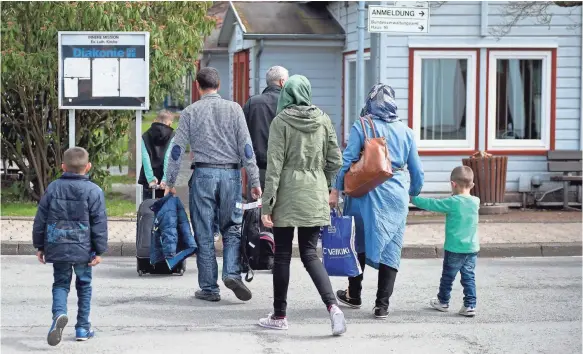  ?? SWEN PFOERTNER, AFP/GETTY IMAGES ?? Refugees from Syria arrive at the Friedland shelter near Goettingen in central Germany on April 4 after arriving from Turkey at the airport in Hanover.