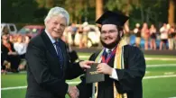  ?? ?? White Hall School Board President Dr. Raymond Jones awards a diploma to Benton Williams.