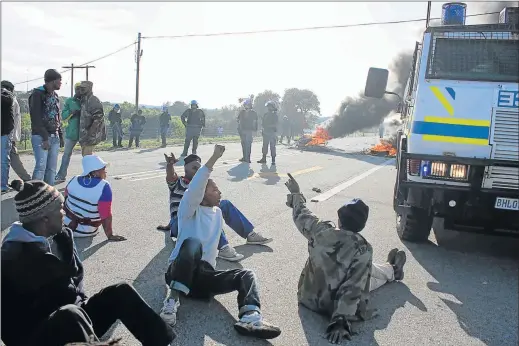  ?? Picture: DAVID MACGREGOR ?? NOT BUDGING: Public order police from East London move in on service delivery protestors blocking the R72 near Kenton-on-Sea yesterday