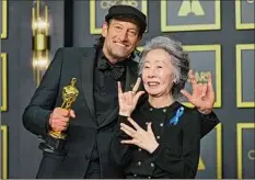  ?? Mike Coppola / Getty Images ?? Troy Kotsur, winner of the Actor in a Supporting Role award for “CODA” and presenter Youn Yuh-jung pose in the press room during the 94th annual Academy Awards Sunday.