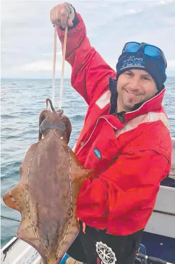  ?? Picture: CRANBOURNE FISHING WORLD ?? TAKE A SQUIZ AT THIS: AJ Azzopardi with one of the large squid he caught while fishing off Queensclif­f last week.