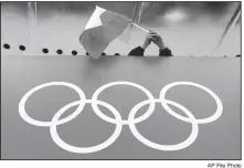  ?? AP File Photo ?? A Russian skating fan holds the country’s national flag over the Olympic rings before the men’s 10,000-meter speedskati­ng race on Feb. 18, 2014, at Adler Arena Skating Center during the Winter Olympics in Sochi, Russia.