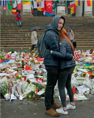  ?? AP ?? A couple embrace in front of tributes placed in a memorial for victims of the recent attacks on Brussels at the Place de la Bourse in Brussels on Friday. —