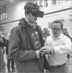  ?? CARLA ALLEN ?? A Deloitte representa­tive helps NSCC business administra­tion student JeanPacal Wilson don virtual reality wearables in preparatio­n for a session.