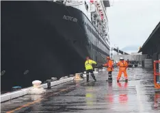  ??  ?? WATER, WATER EVERYWHERE: Workers at the Cairns Cruise Liner Terminal secure the visiting ship Pacific Aria when it arrived yesterday morning.