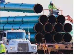  ?? (AP) ?? Workers unload pipe in Worthing, S.D., for the Dakota Access oil pipeline in 2015. American Indian tribes opposed to the pipeline have asked a federal judge to halt it.