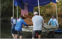  ??  ?? Five men carry the raft into the Sacramento River on Sunday morning at Irvine Finch Boat Launch.