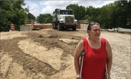  ?? RICHARD PAYERCHIN — THE MORNING JOURNAL ?? Wanda Wright stands atop the roadway that was built up as an approach to the new High Bridge Road bridge under constructi­on in Vermilion, on June 23, 2018. Wright, her husband, Leon, and son, Robert, say the slope of the bridge approach has created a steep driveway for their property and will be a drainage problem in heavy rain and snow.