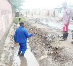  ??  ?? PF Ngwerere Ward 19 councillor Adrian Banda in blue overall clears a drainage