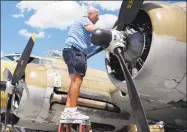  ?? Jesse Tinsley / Associated Press ?? In a photo from July 1, Ernest “Mac” McCauley, a veteran pilot who volunteere­d with the Collings Foundation, works on one of the ninecylind­er radial engines on a B17 Flying Fortress bomber on display at the Spokane Internatio­nal Airport in Spokane, Wash. McCauley, 75, of Long Beach, Calif., and his copilot were among seven people killed when the bomber crashed and burned last Wednesday at Bradley Internatio­nal Airport in Windsor Locks.