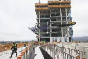  ?? Photos by Santiago Mejia / The Chronicle ?? This 24story tower under constructi­on will be the final phase of the transit village at MacArthur BART Station.