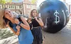  ?? PAUL J. RICHARDS/AFP/GETTY IMAGES ?? People pull a mock “ball and chain” symbolizin­g student debt in St. Louis.