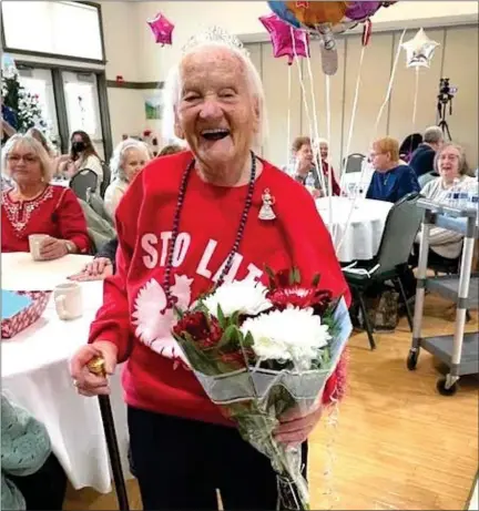 ?? COURTESY OF JOANNA REGAN ?? Mary Nowalk, who recently celebrated her 100th birthday, is pictured with her new Boston Post Cane and a bouquet of flowers.