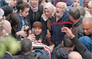  ?? ?? The grandparen­ts of one of Palestinia­ns killed during clashes with Israeli army forces mourn with others around the body during the funeral in their home village of Beit Rima in the occupied West Bank on Tuesday.