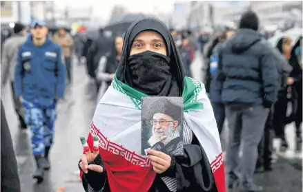  ?? EBRAHIM NOROOZI
AP ?? An Iranian woman holds up a portrait of Iranian Supreme Leader Ayatollah Ali Khamenei, as she makes the victory sign during a rally marking the 40th anniversar­y of the 1979 Islamic Revolution, in Tehran, Iran, on Monday. •