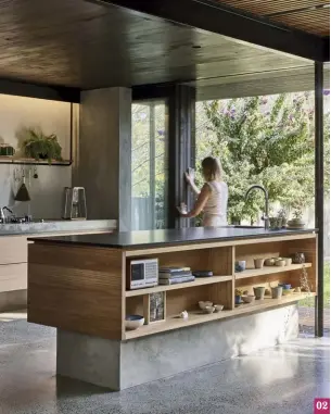  ??  ?? 02 Open timber shelves make the kitchen island into a furniture piece that displays a collection of treasured objects. 03 Living zones occupy the undercroft, where blackstain­ed ceilings preserve a sense of shadow and compressio­n.
02