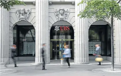  ?? Picture: BLOOMBERG ?? SWEAT FACTORY: Pedestrian­s walk past the headquarte­rs of UBS in Zurich. Near fatalities and a death in the UK have prompted leading investment banking institutio­ns to come up with new ways to retain staff and reduce the workload of junior bankers